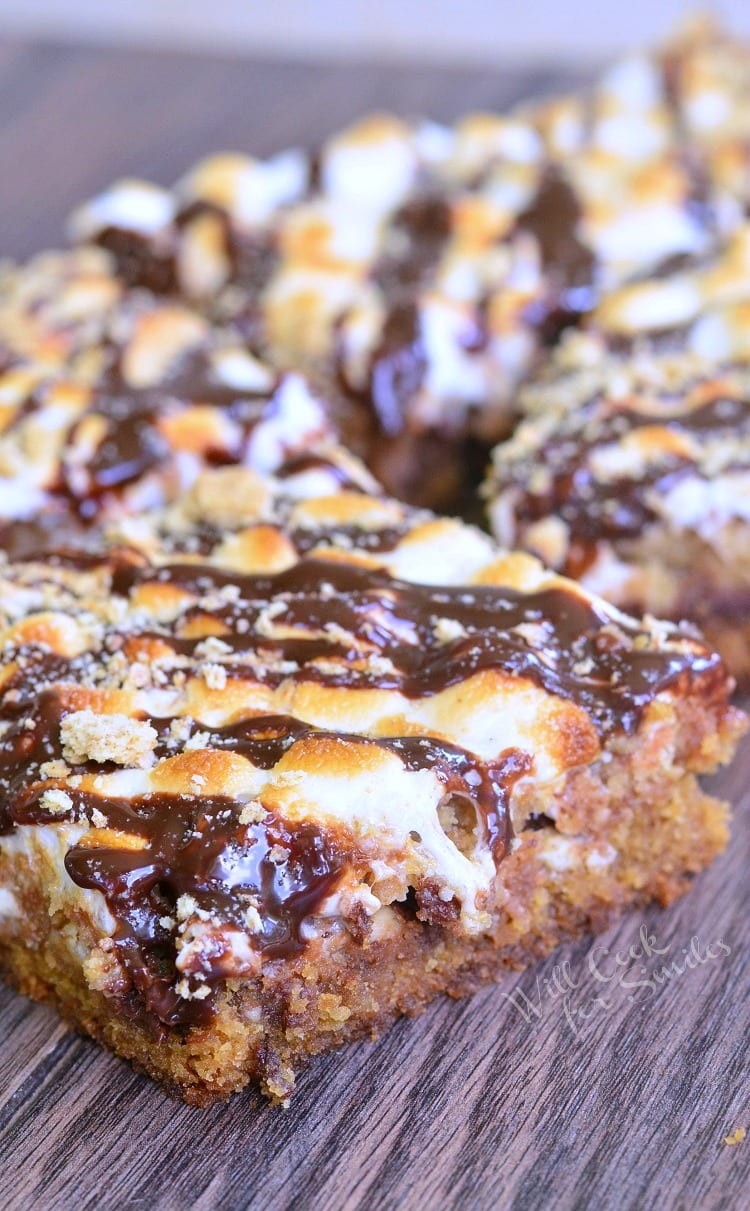  S'Mores Crumble Cookie Bars with melted marshmallows on top stacked up on top of each other 