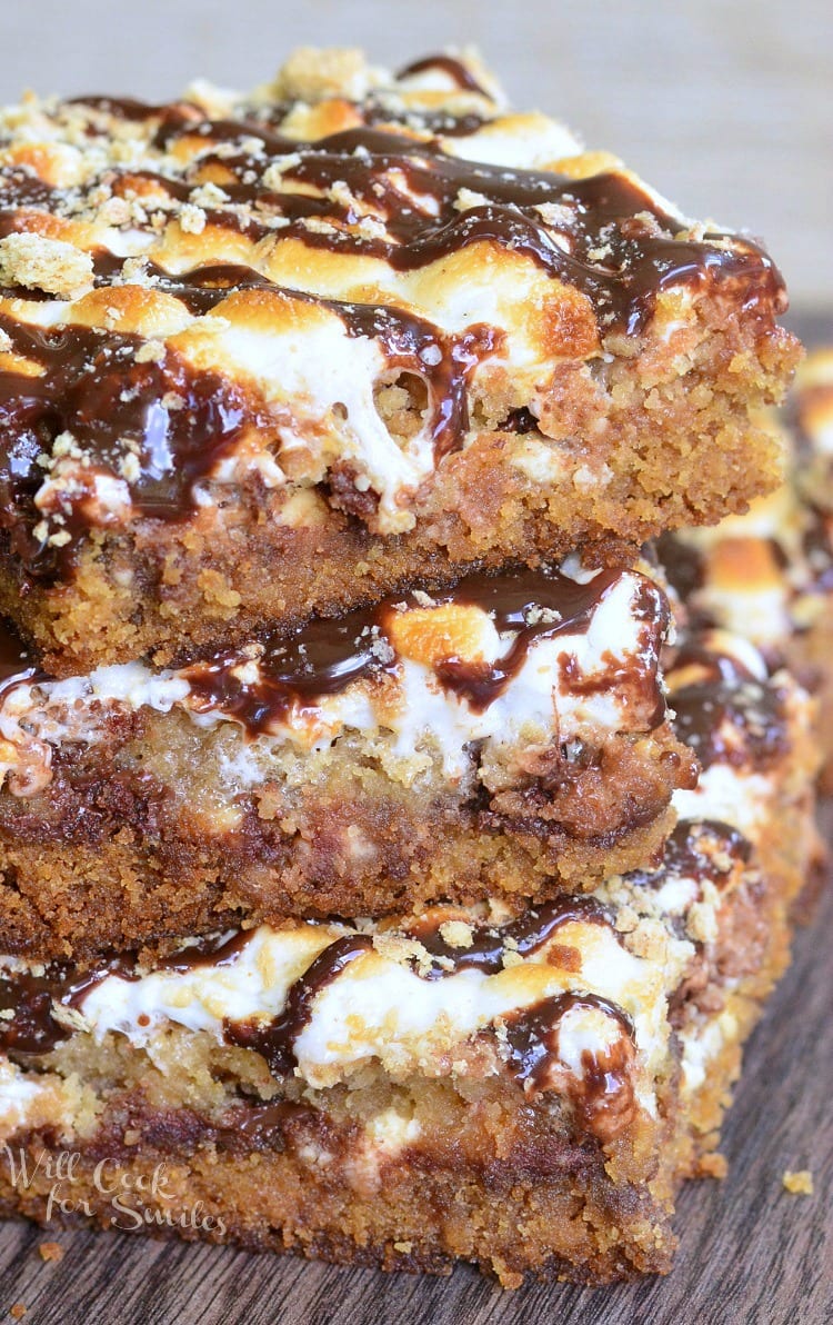  S'Mores Crumble Cookie Bars with melted marshmallows on top stacked up on top of each other 