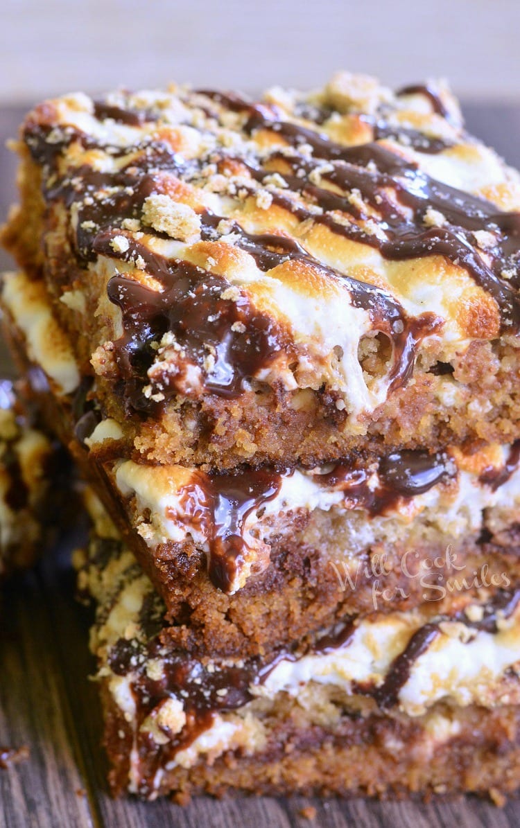  S'Mores Crumble Cookie Bars with melted marshmallows on top stacked up on top of each other 