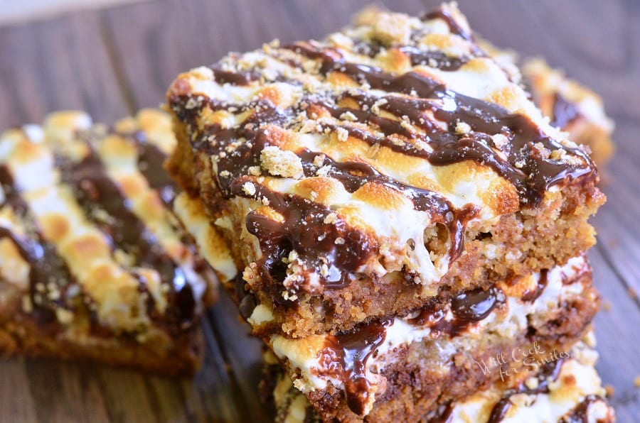  S'Mores Crumble Cookie Bars with melted marshmallows on top stacked up on top of each other 