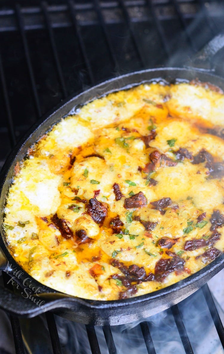 Smokey Sun-Dried Tomato and Basil Mozzarella Dip in a cast iron pan on the grill 