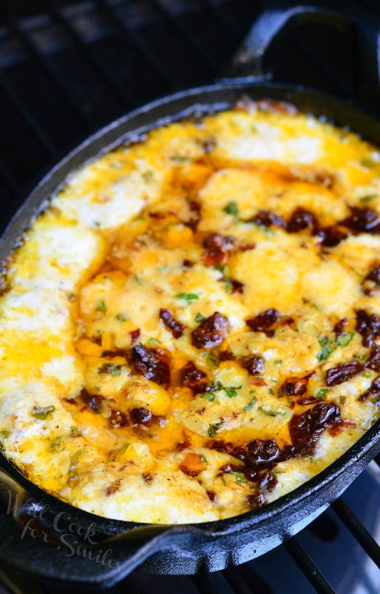 Smokey Sun-Dried Tomato and Basil Mozzarella Dip in a cast iron pan on the grill 