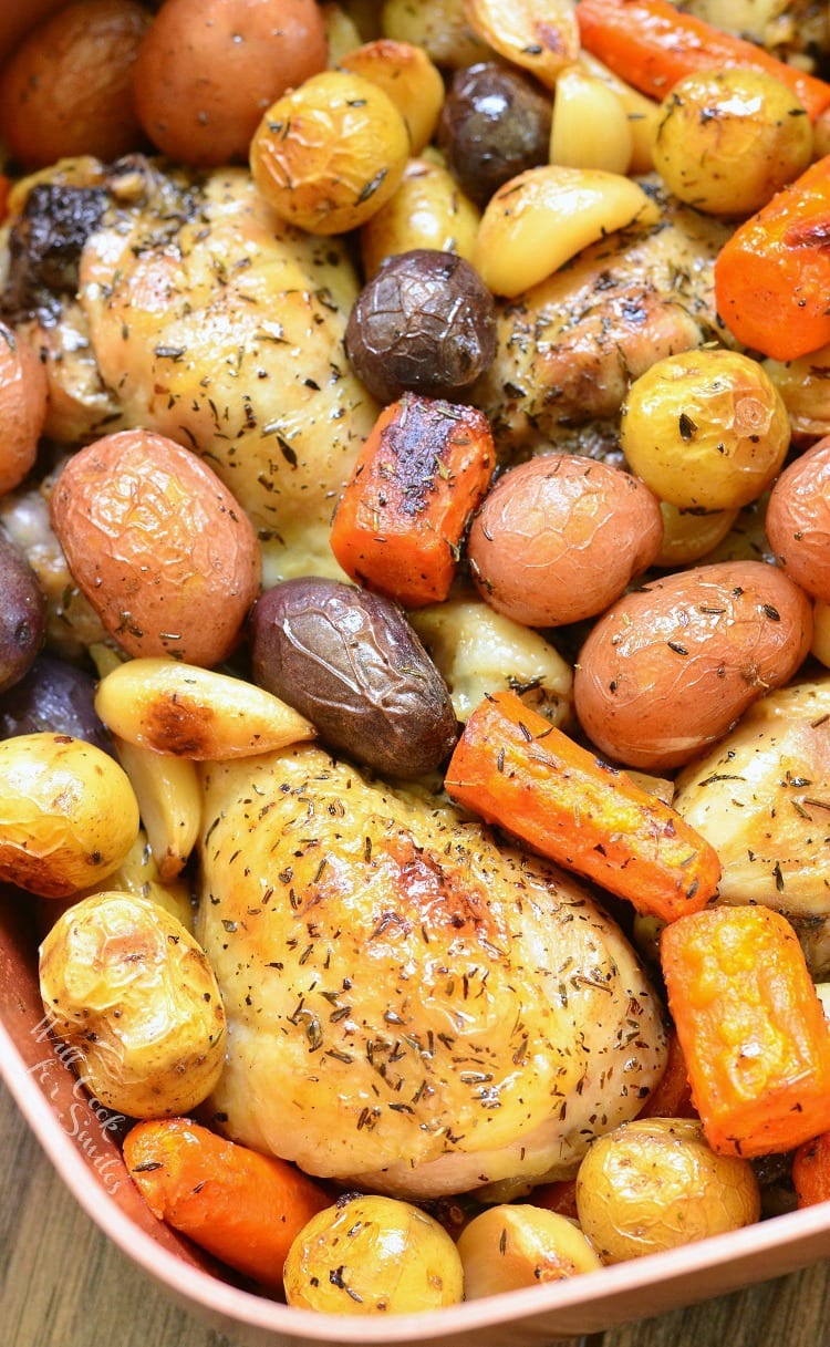 Chicken Drumsticks, garlic, potatoes, and carrots in a pan