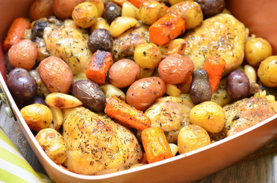 Chicken Drumsticks, garlic, potatoes, and carrots in a pan