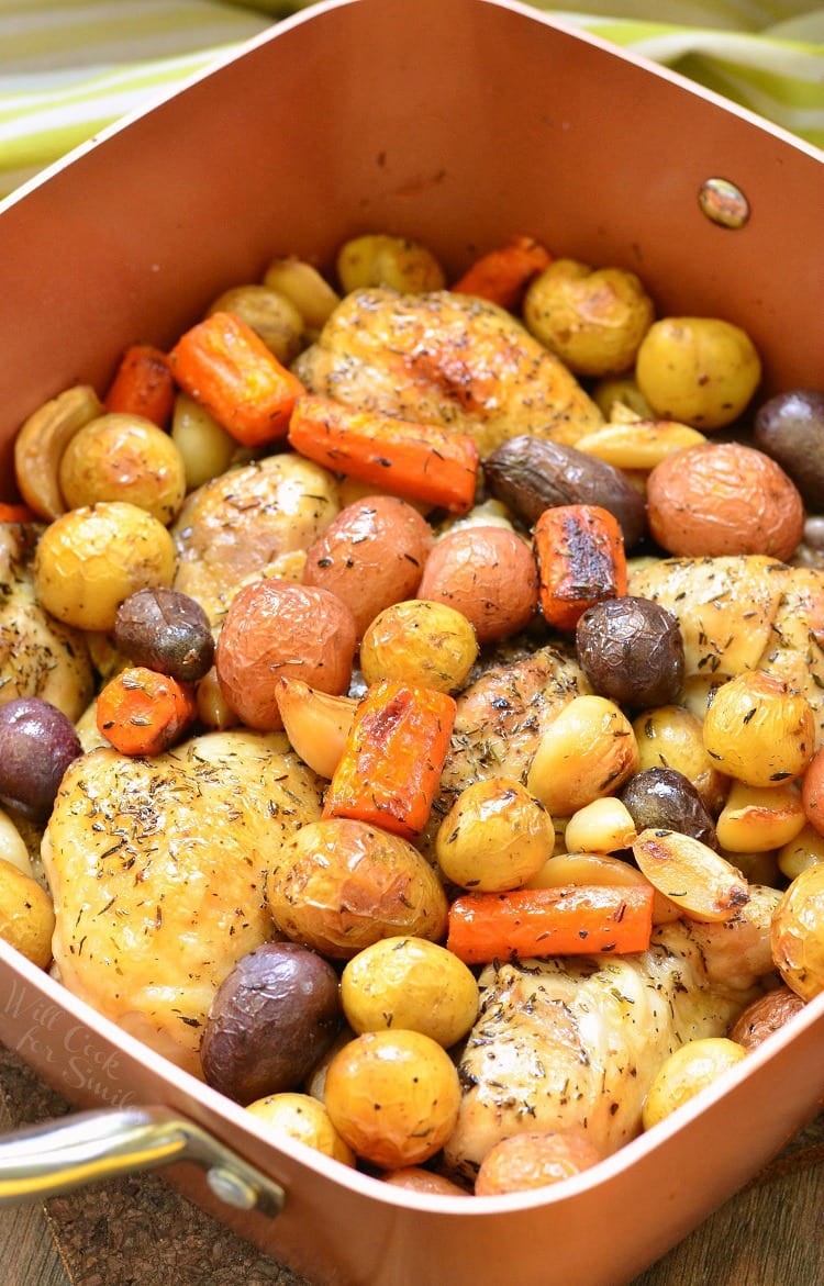 top view photo of Chicken Drumsticks, garlic, potatoes, and carrots in a pan