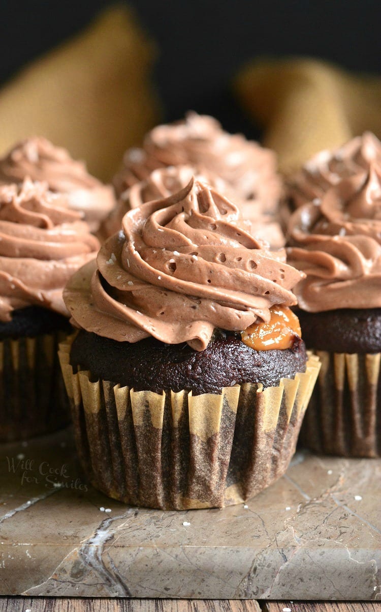 Chocolate cupcake with salted dulce de leche filling sitting on a stone counter