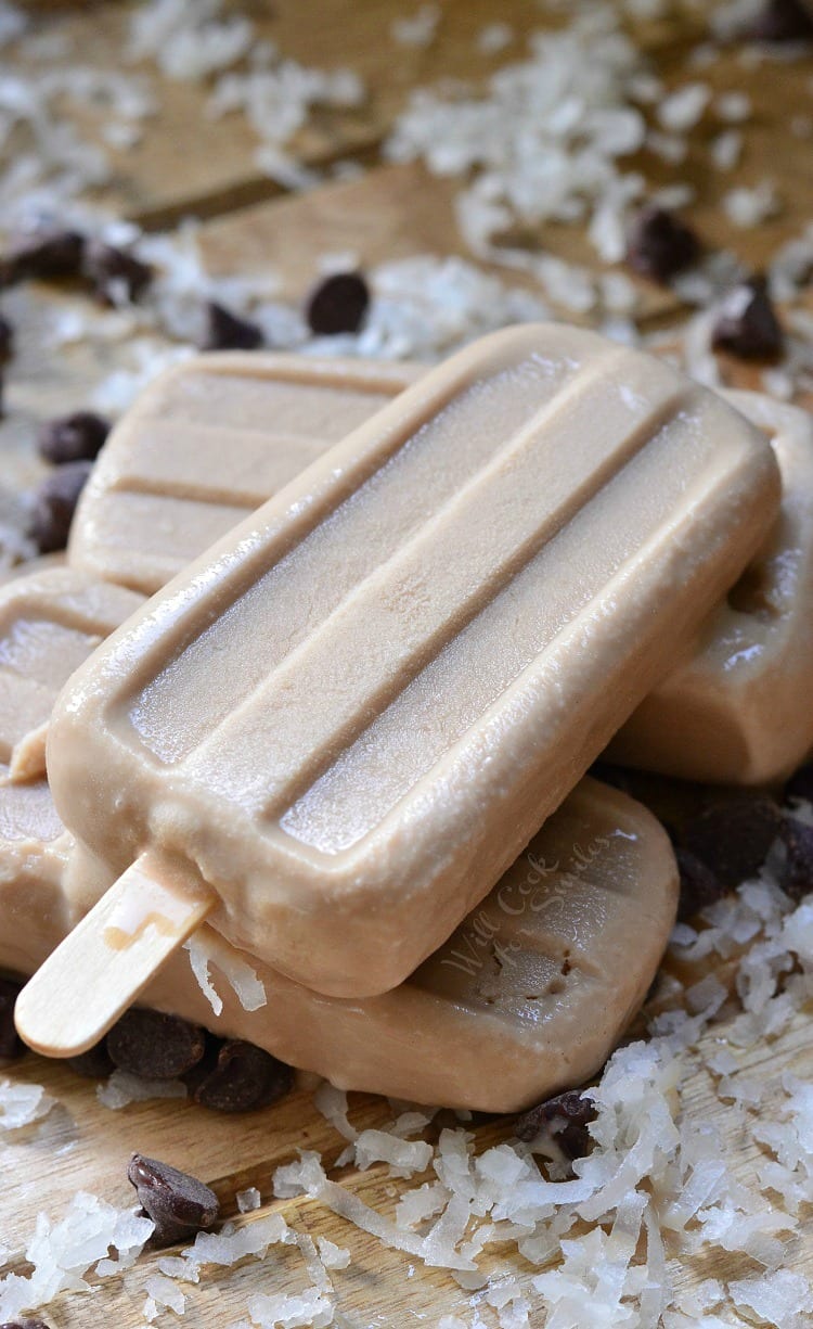 Coconut Mocha Ice Pops stacked up on a cutting board with coconut flakes 