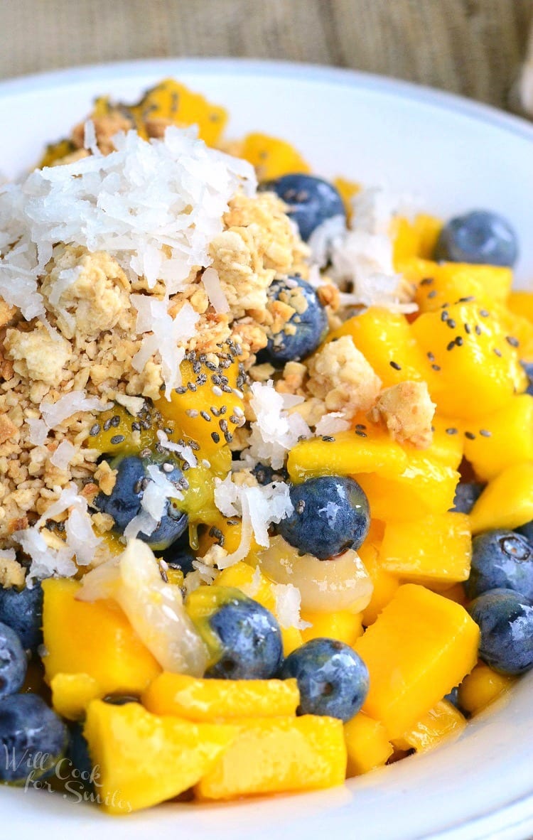 Mango, Lychee, and Blueberry with granola and coconut flakes on top in a bowl 