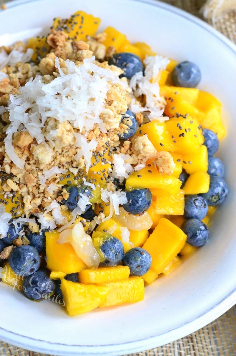 White bowl filled with mango lychee and blueberry fruit bowl as viewed from above