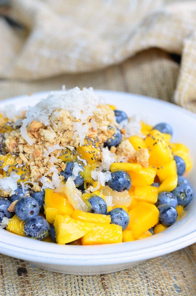 Mango, Lychee, and Blueberry with granola and coconut flakes on top in a bowl 