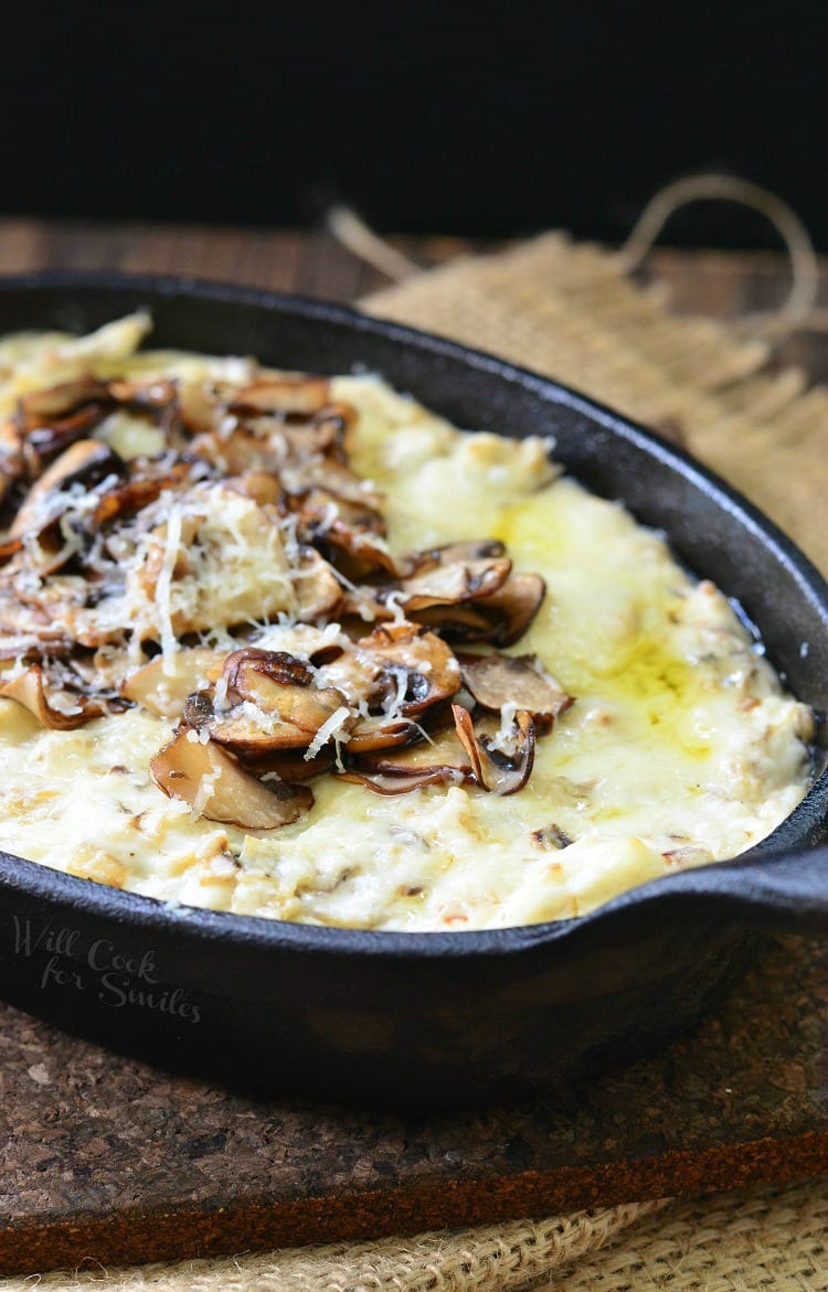 Mushroom Leek and Gruyere Cheese Dip with mushrooms on the top in a cast iron pan 