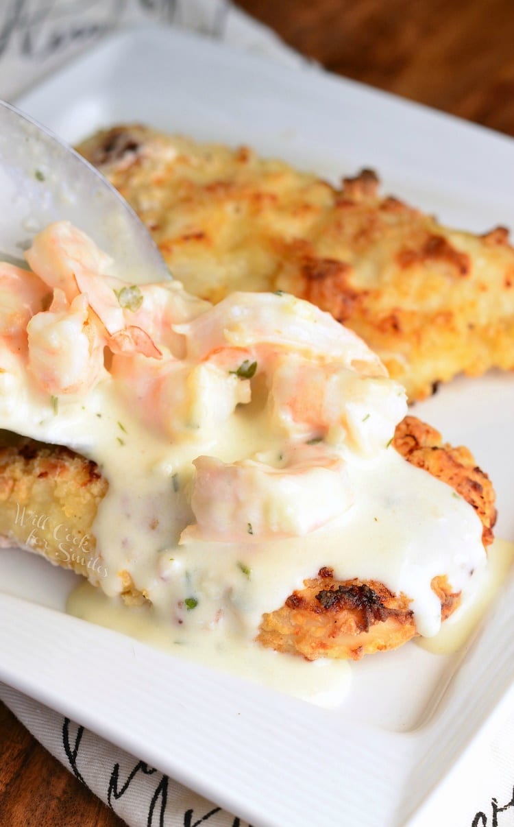 Oven Fried Chicken topped with shrimp and a Creamy Fontina cheese Shrimp Sauce on a white plate