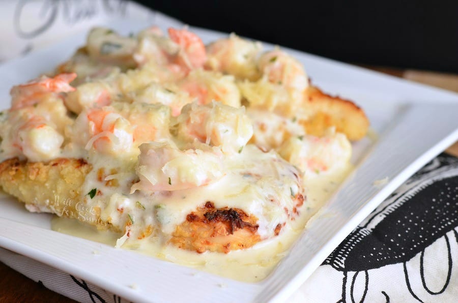Oven Fried Chicken topped with shrimp and a Creamy Fontina cheese Shrimp Sauce on a white plate