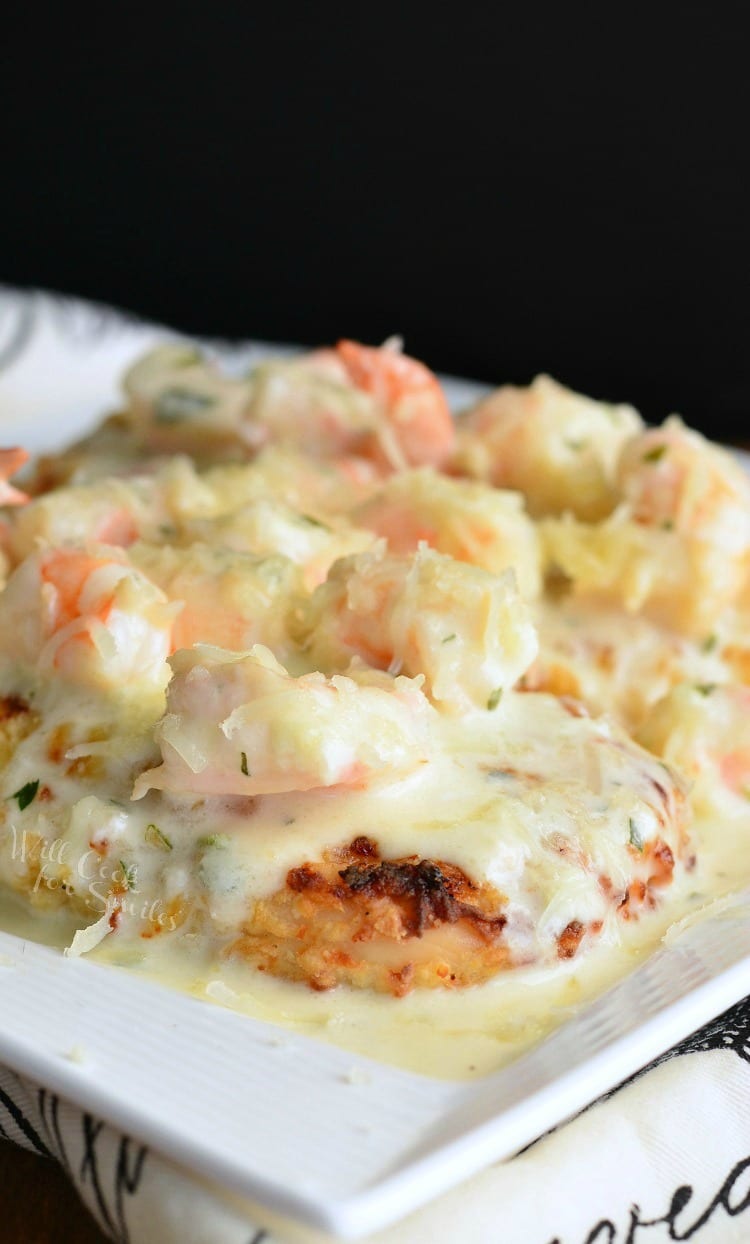 white decorative plate with oven fried chicken topped with creamy fontina shrimp sauce as viewed from above
