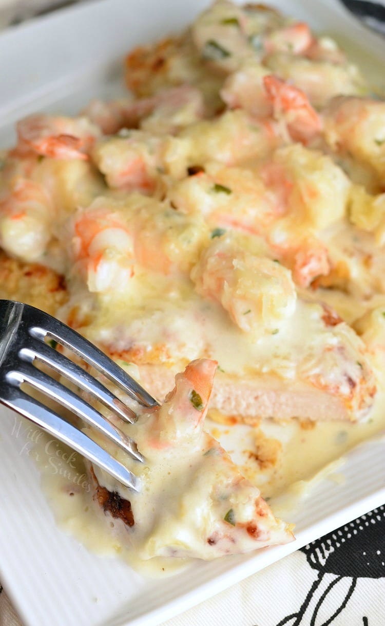 top view Oven Fried Chicken topped with shrimp and a Creamy Fontina cheese Shrimp Sauce on a white plate