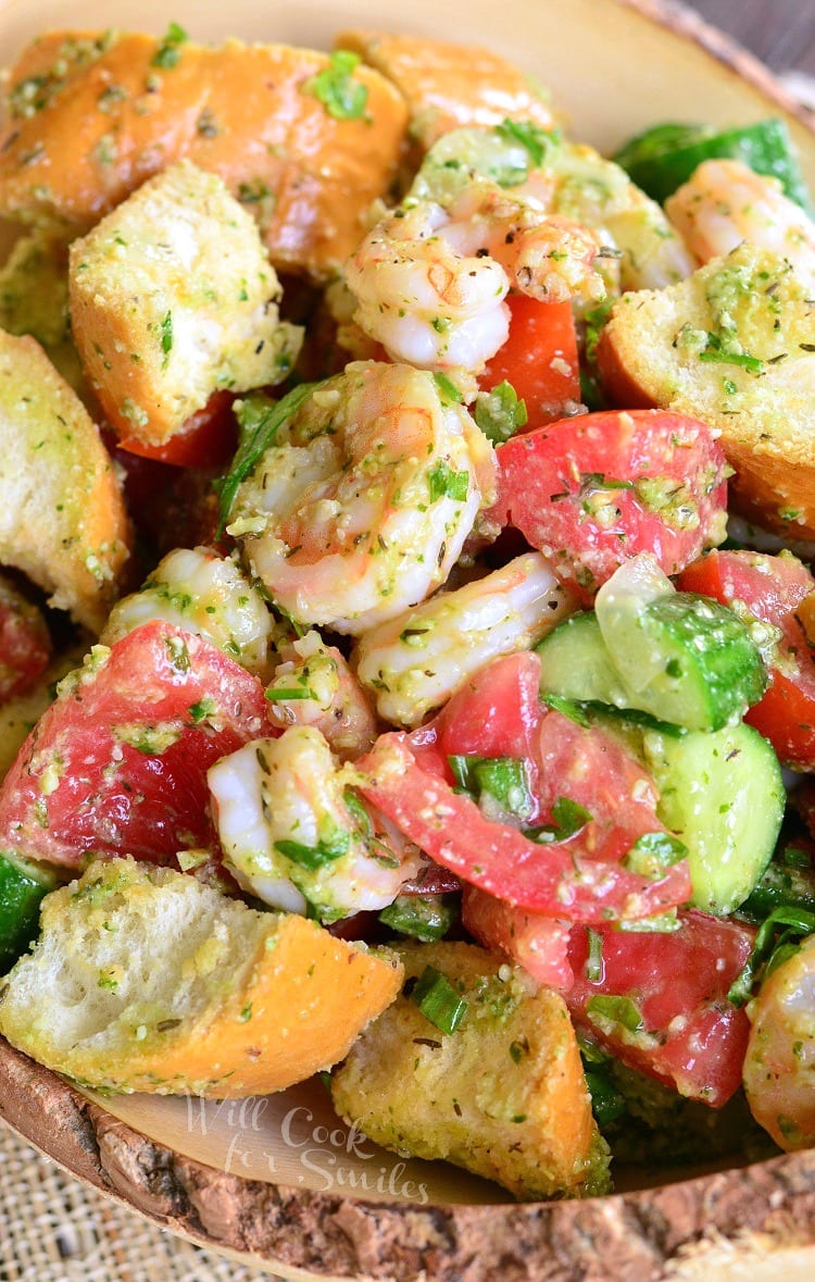 top view of Panzanella Salad with Shrimp, tomato, and cucumber, and bread with Pesto in a bowl 