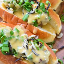 3 beer cheese jalapeno brats in rolls on a wooden table as viewed from above