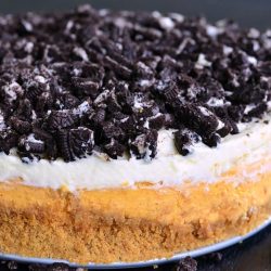 Layered Oreo Pumpkin Cheesecake on a black table as viewed close up