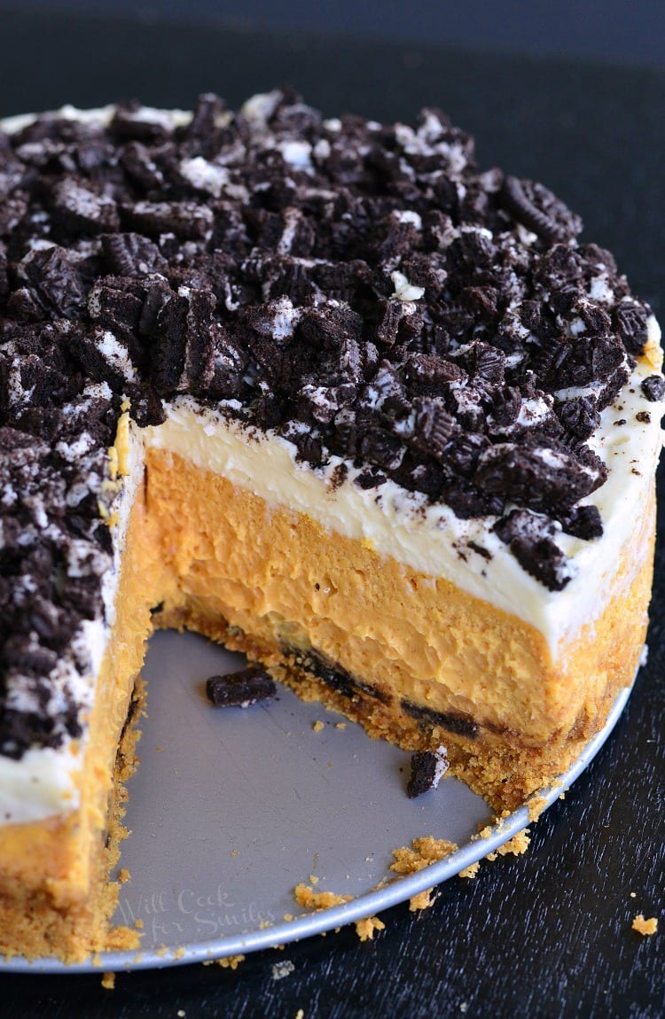 Layered Oreo Pumpkin Cheesecake with a slice missing 