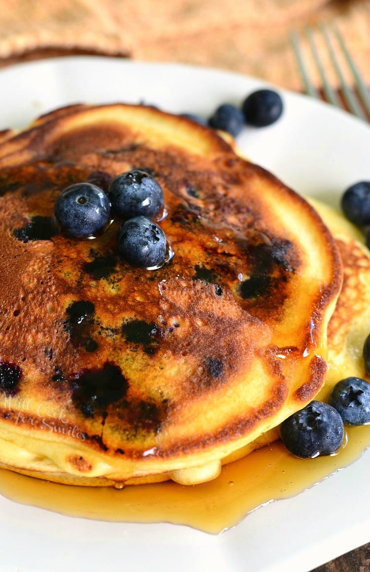 close up of pancakes with blueberries and maple syrup