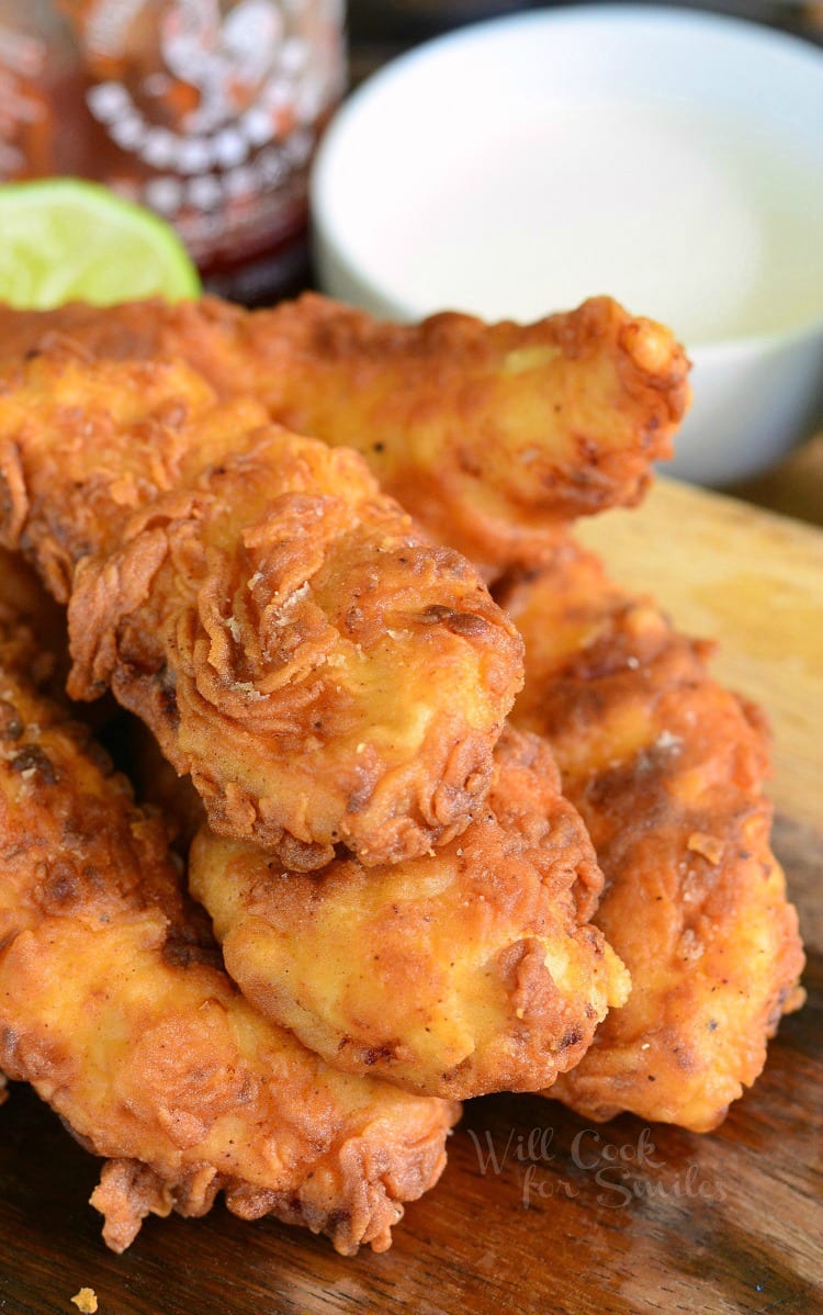 Sriracha Chicken Tenders stacked up on a cutting board 