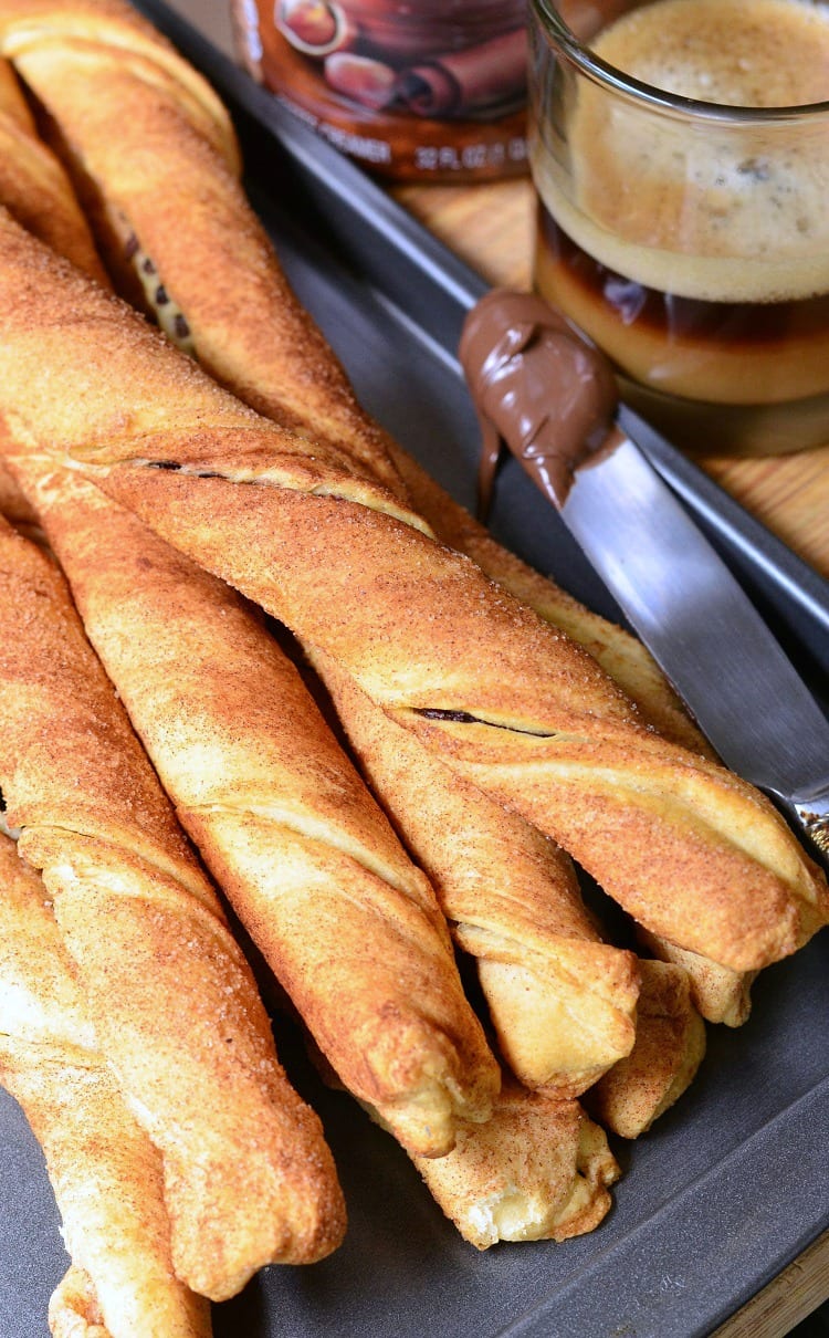 Chocolate Hazelnut Cinnamon Twists on a baking sheet with some Nutella on a knife to the right 