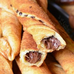 a stack of chocolate hazelnut cinnamon twists on a metal baking tray with some of the sticks broken in half.