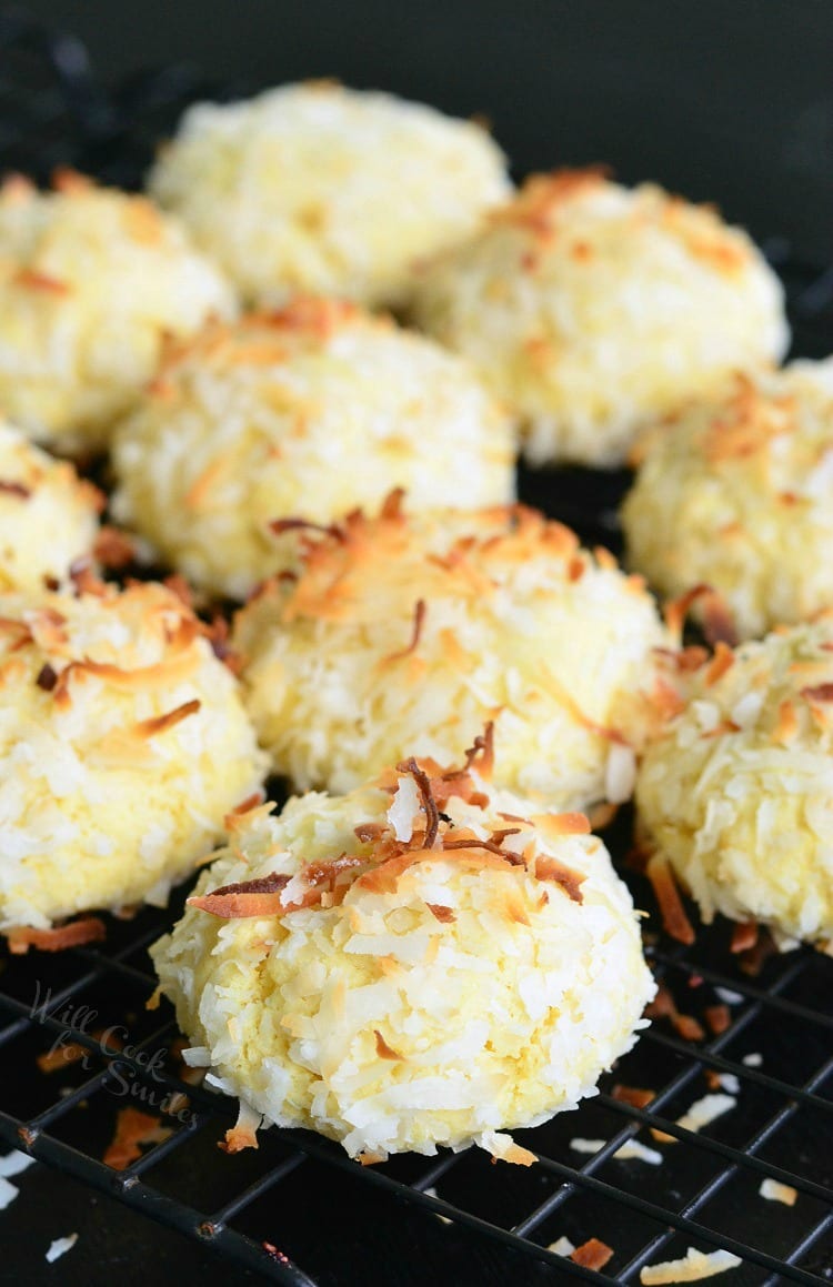 Coconut Pudding Cookies with coconut flakes on top stacked on a cooling rack 