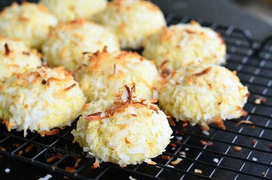 Coconut Pudding Cookies with coconut flakes on top stacked on a cooling rack 