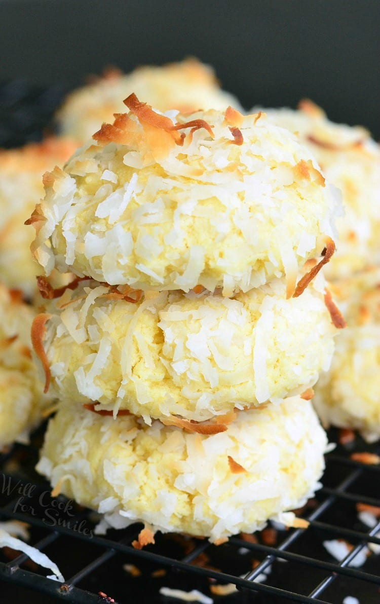 Coconut Pudding Cookies with coconut flakes on top stacked on a cooling rack 