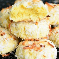 Coconut pudding cookies on a wire rack resting on a black table.