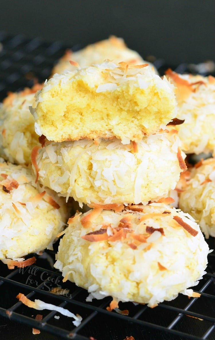 Coconut Pudding Cookies with coconut flakes on top stacked on a cooling rack 
