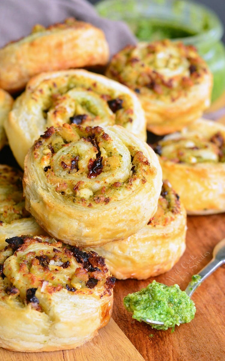 Pesto Chicken Pinwheels - Flaky pastry, juicy chicken, fresh pesto, sun dried tomatoes, and feta cheese rolled together to create a snack to delight your taste buds. 