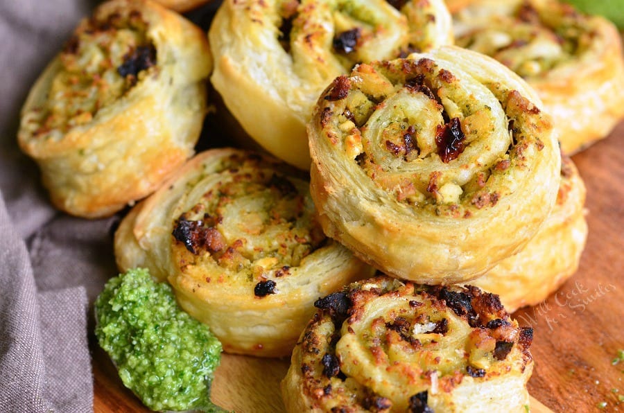 Pesto Chicken Pinwheels - Flaky pastry, juicy chicken, fresh pesto, sun dried tomatoes, and feta cheese rolled together to create a snack to delight your taste buds. 