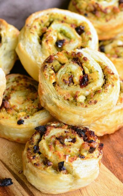 stack of chicken and sun dried tomato pinwheels on a wooden cutting board as seen from above.