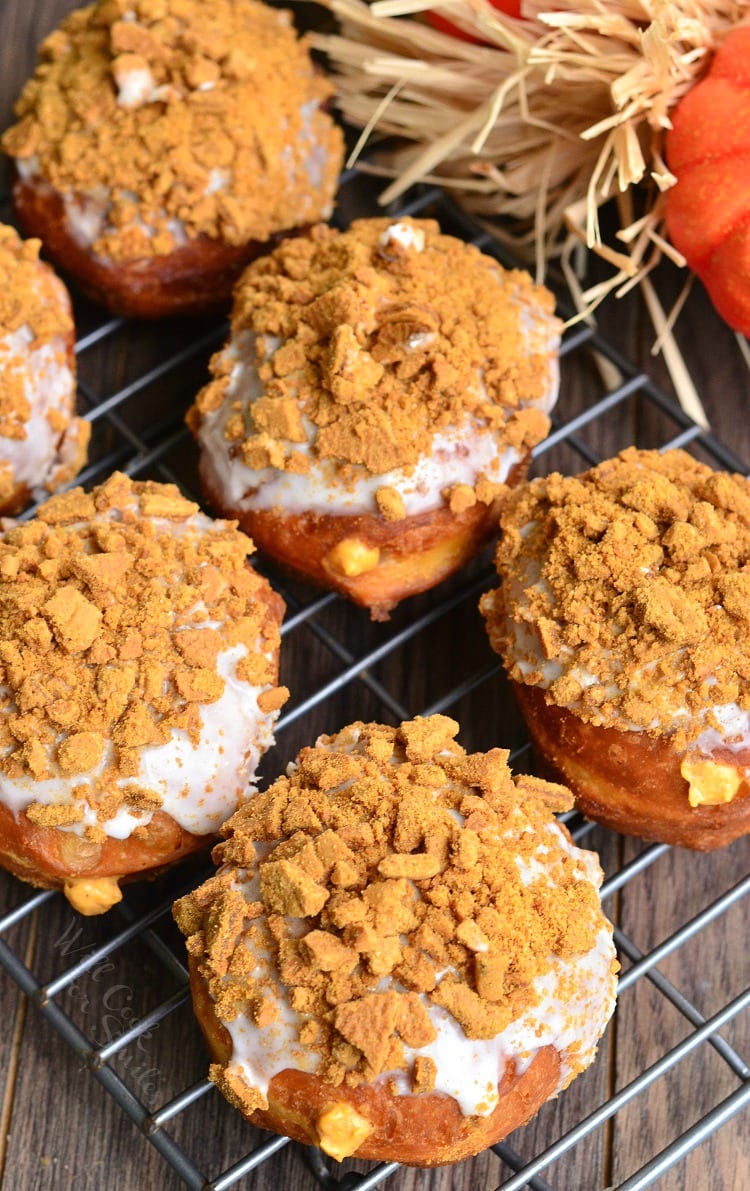 top view Pumpkin Cheesecake Doughnuts with Gingersnap Crumb on top on a cooling rack 