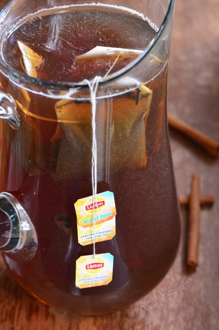 Spiced Iced Tea in a pitcher with teabags on a wood table 