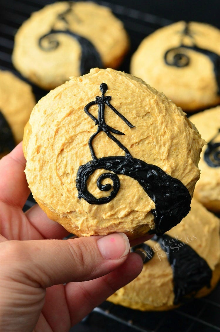Holding a The Nightmare Before Christmas Cookies. Orange frosted cookies some with Jack made out of frosting 