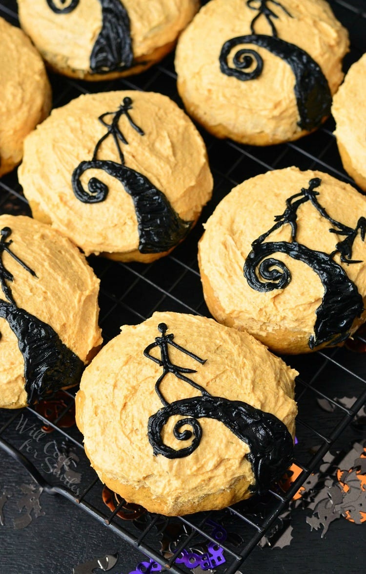 The Nightmare Before Christmas Pumpkin Cookies with orange frosting on a cooking rack 