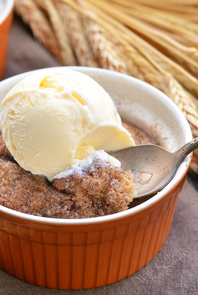 Pumpkin Pie Spice Blondies with ice cream on top in an orange ramekin with a spoon scooping some out