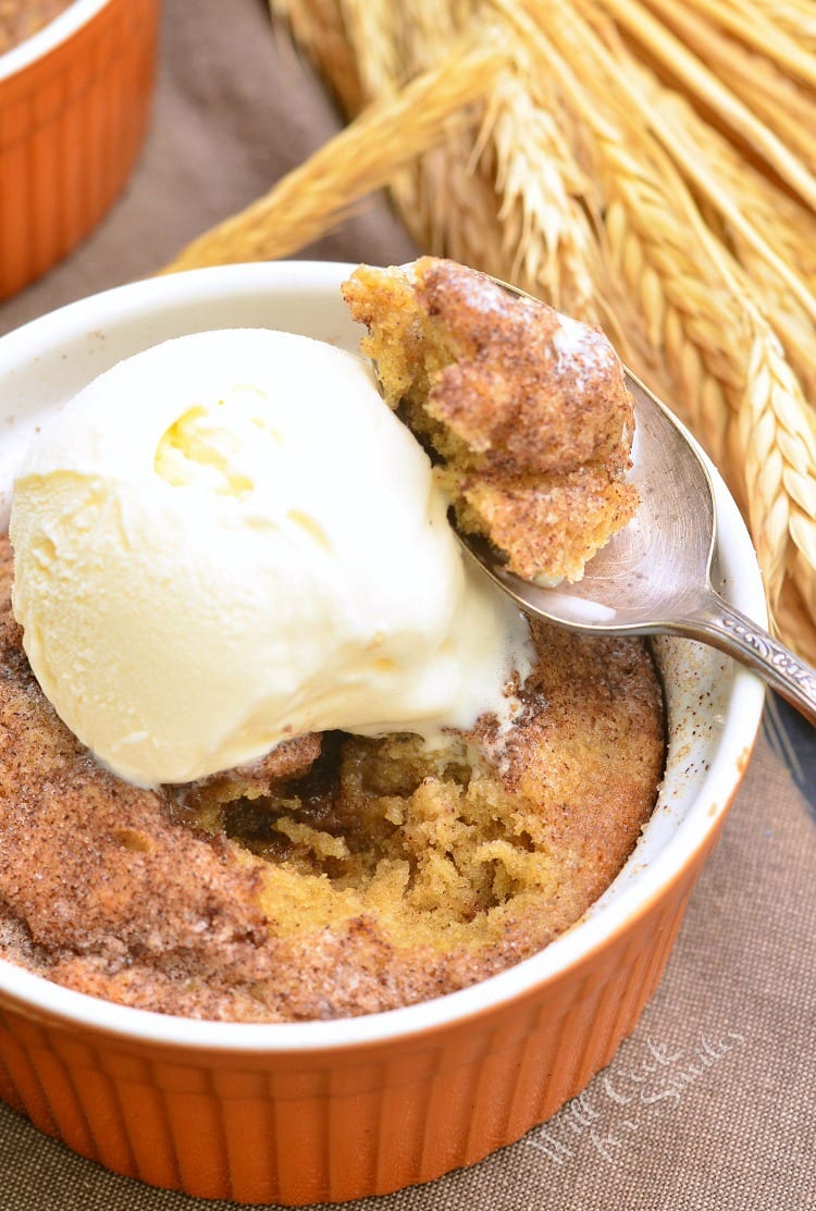 Pumpkin Pie Spice Blondies with vanilla ice cream on top in an orange ramekin with a spoon with some cake on it 