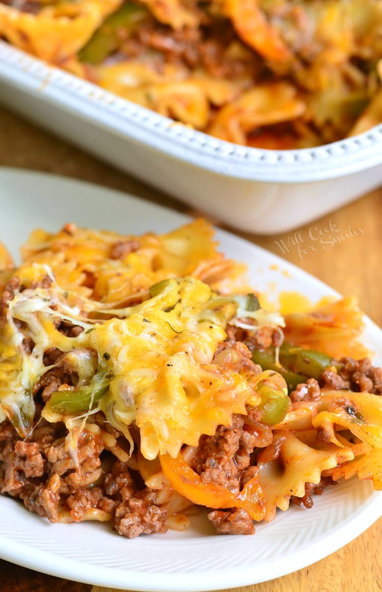 some pasta and beef cooked casserole on a white plate next to the baking dish