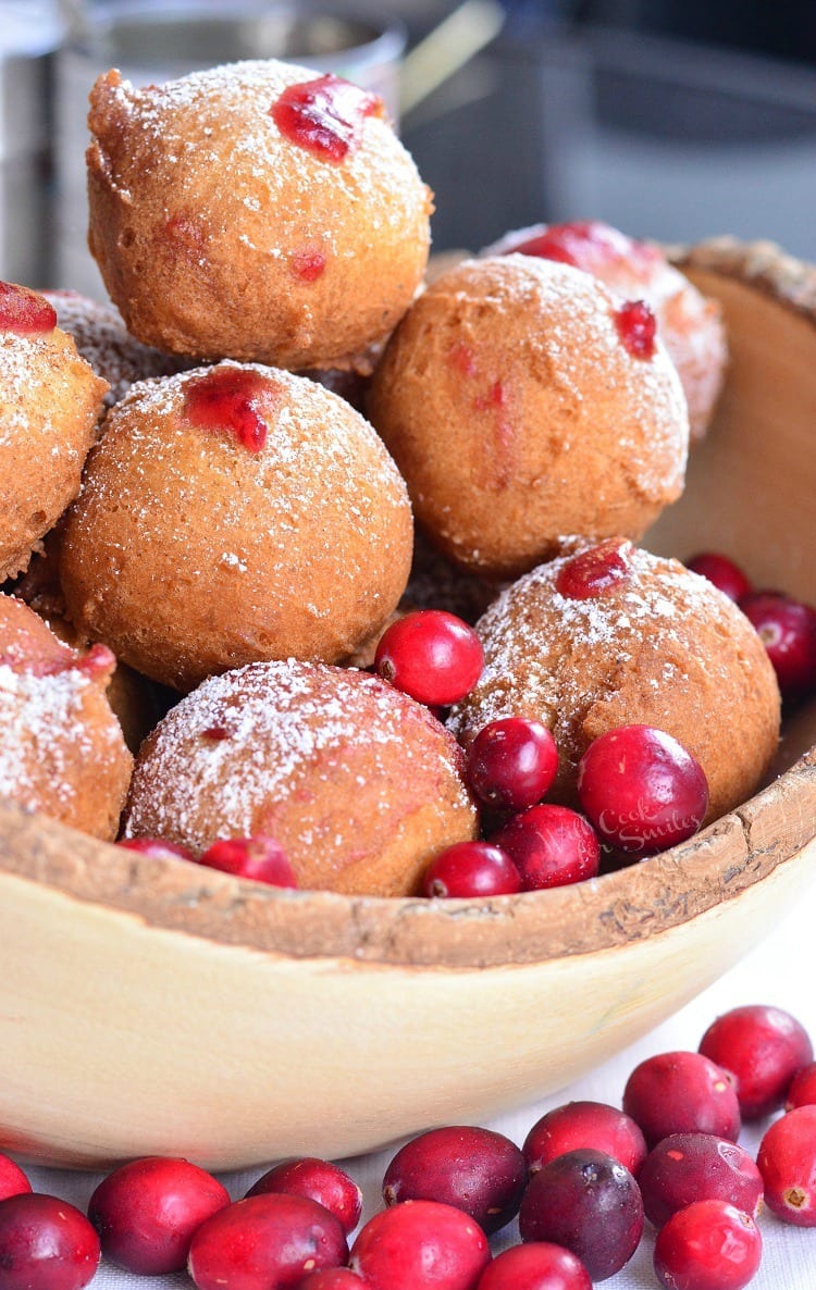 Cranberry Sauce Doughnut Holes in a bowl with cranberries around it 