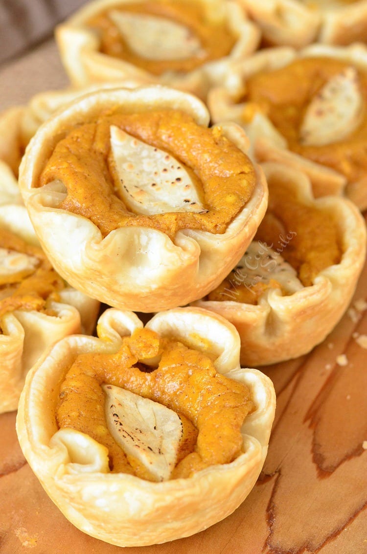 Mini Pumpkin Cheesecake Pies on a wood cutting board 