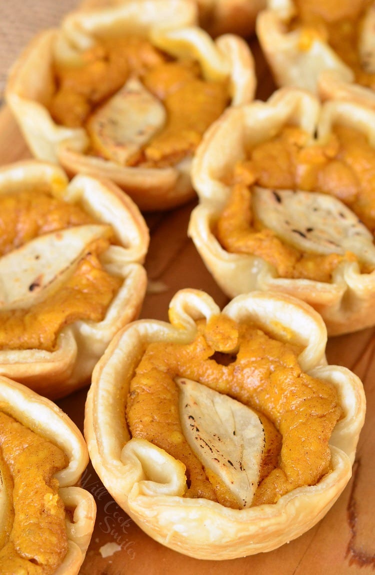 top view of Mini Pumpkin Cheesecake Pies on a cutting board 