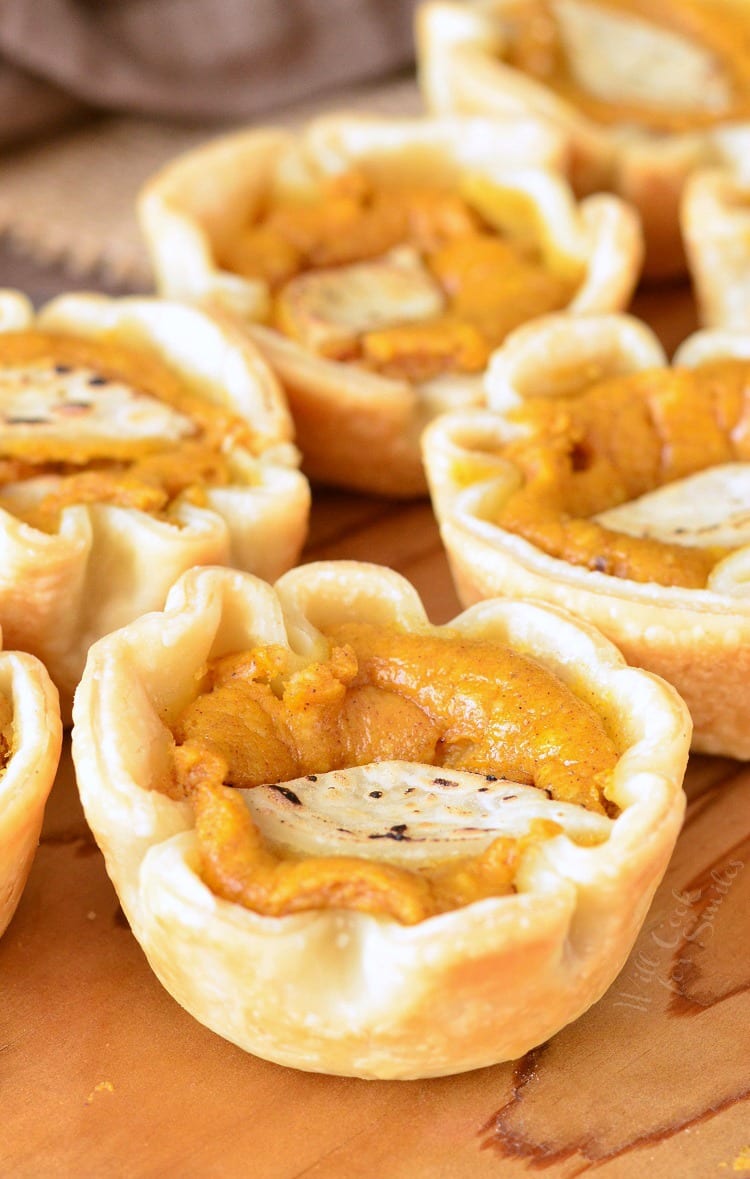 Mini Pumpkin Cheesecake Pies on a wood cutting board 