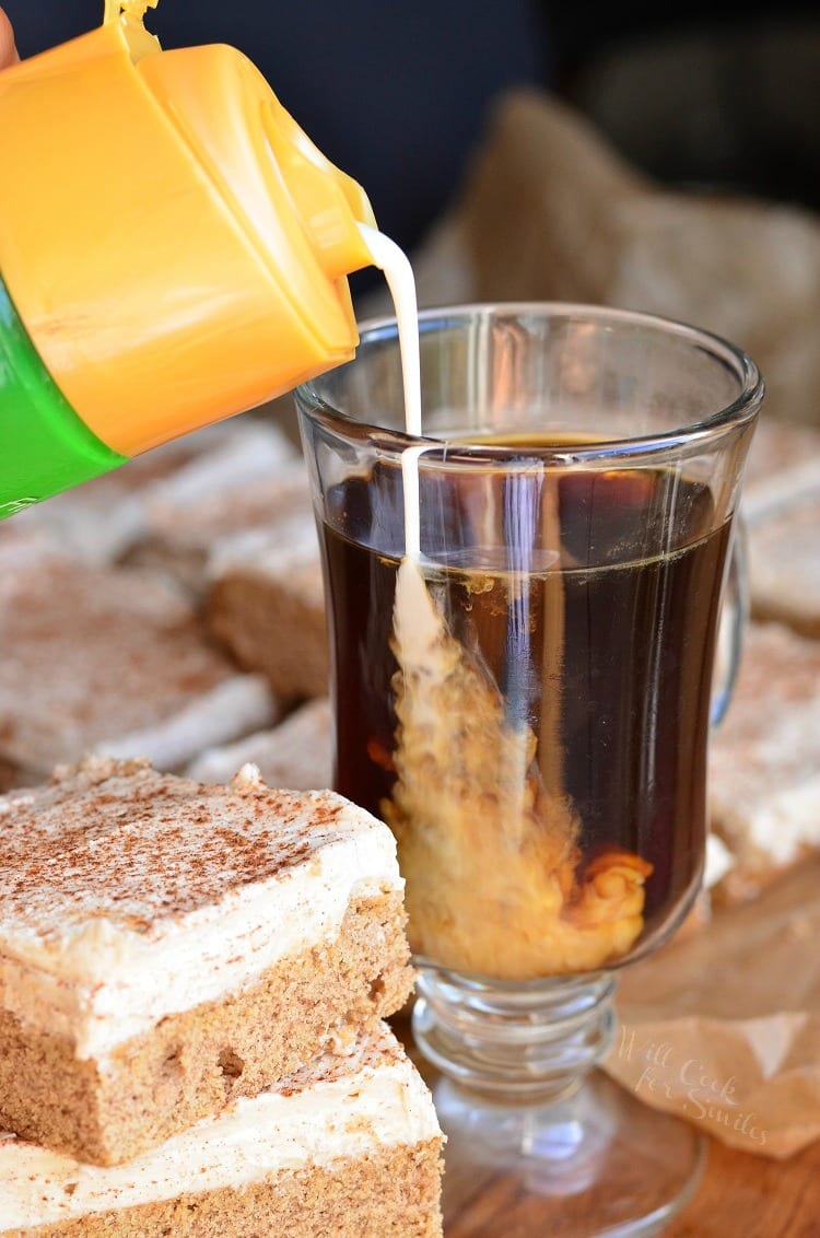 pouring creamer into a clear glass mug 