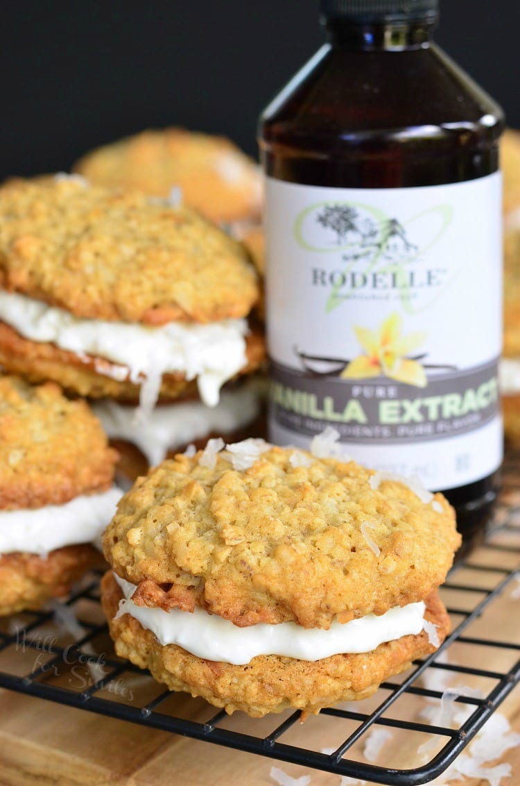 Coconut Oatmeal Cookie Sandwich on a cooling rack with bottle of vanilla extract in the background 