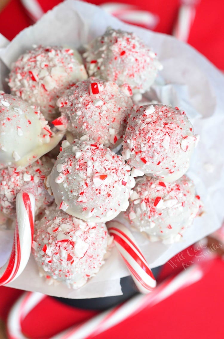 crushed peppermint topped chocolate fudge balls in a white tissue with candy canes around