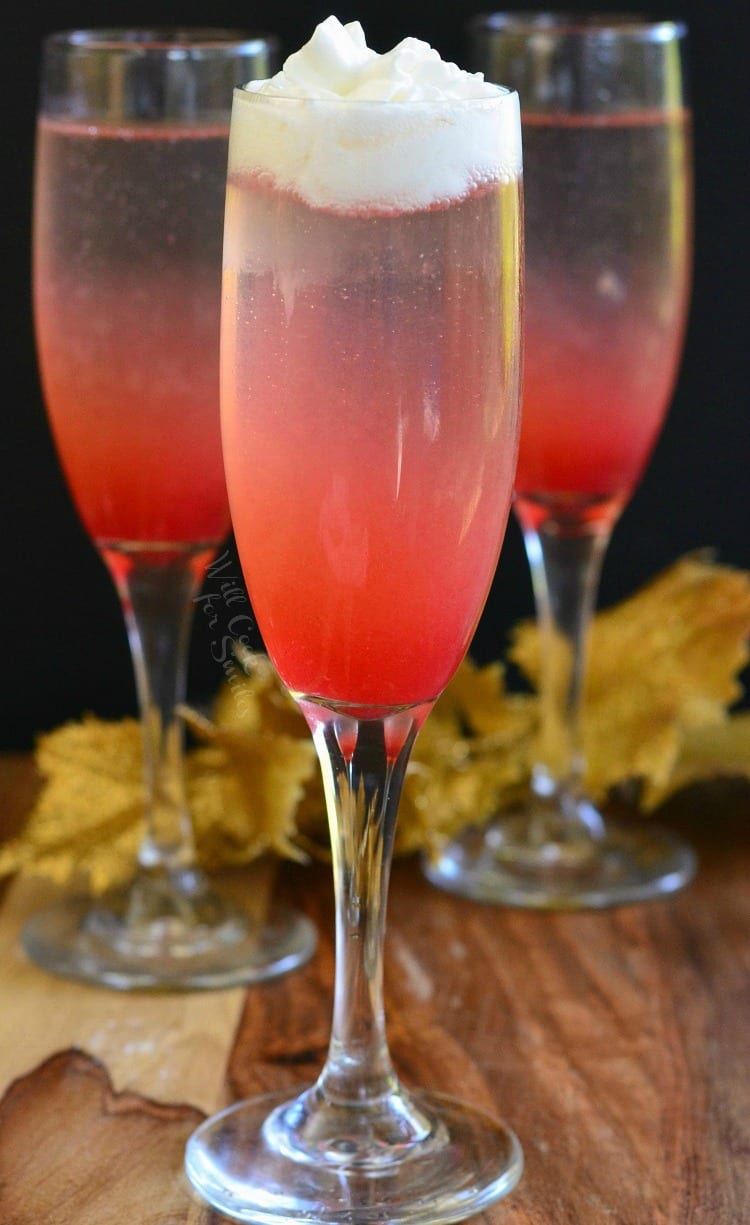 3 Raspberry Italian Soda Champagne Cocktail in a champagne flute on a table 